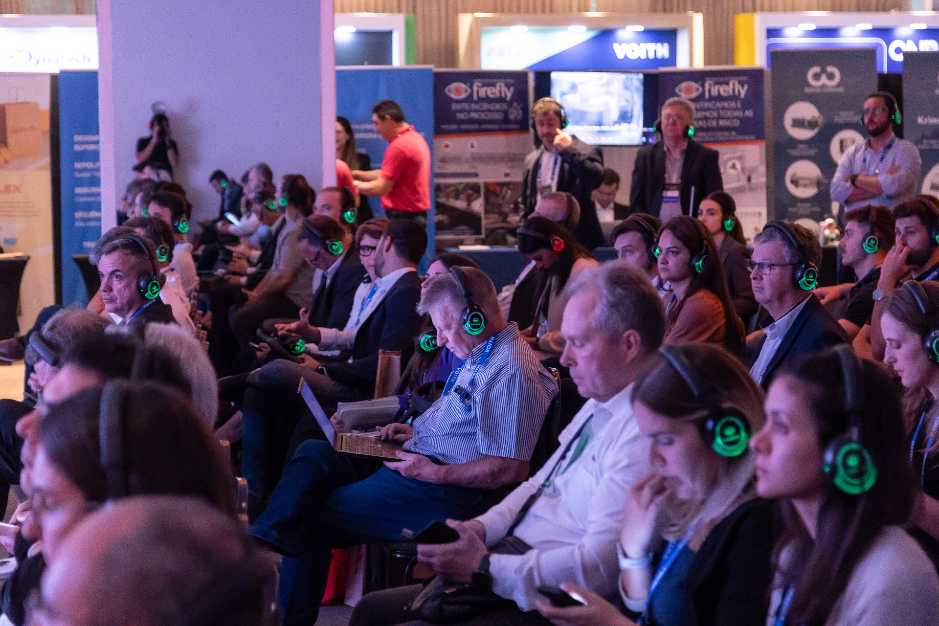Público atento com headsets de tradução simultânea